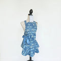 Her Good Eye blue floral print kitchen apron with satin ribbon side bow on a mannequin