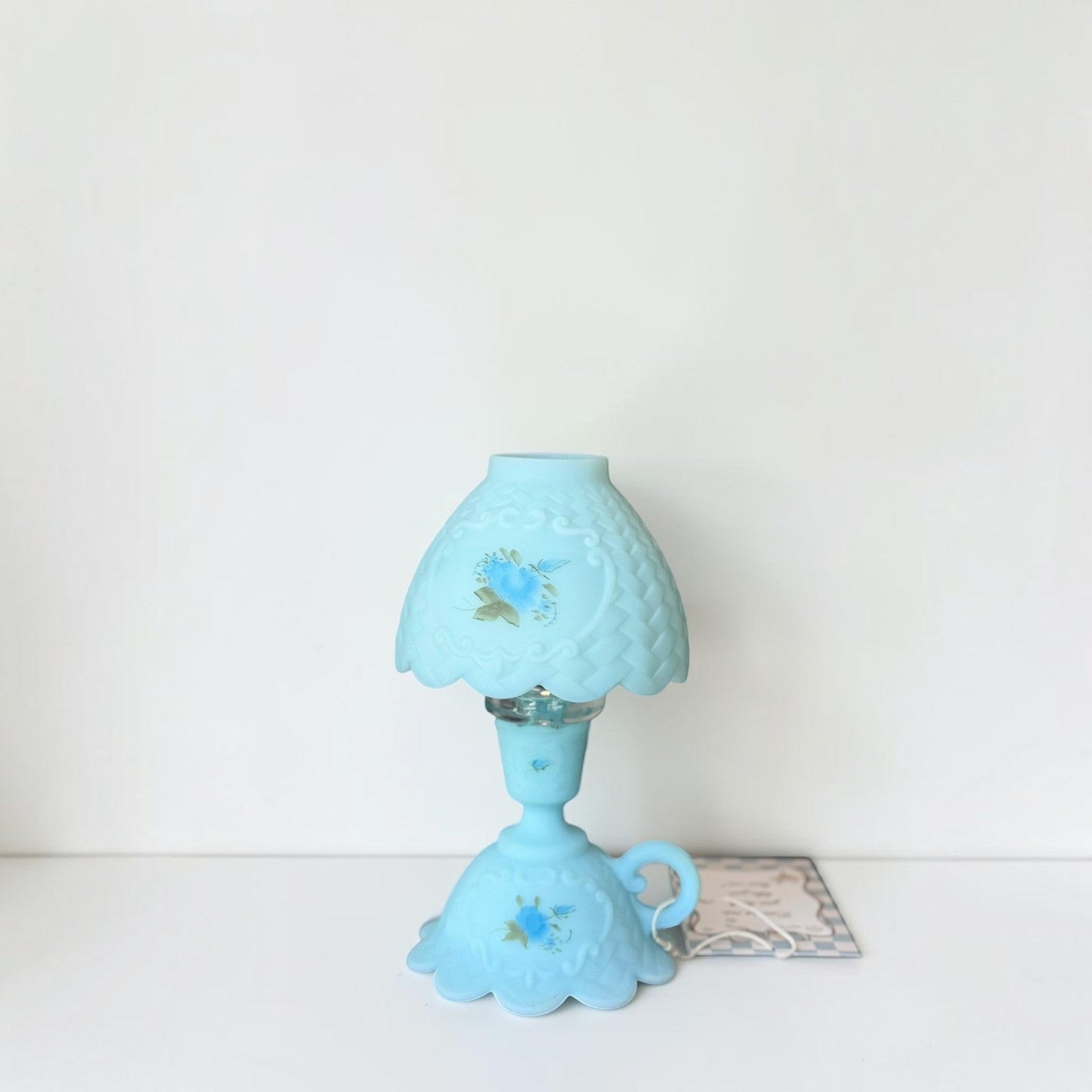 Her Good Eye vintage blue satin glass table lamp with hand-painted floral details and a scalloped silhouette.