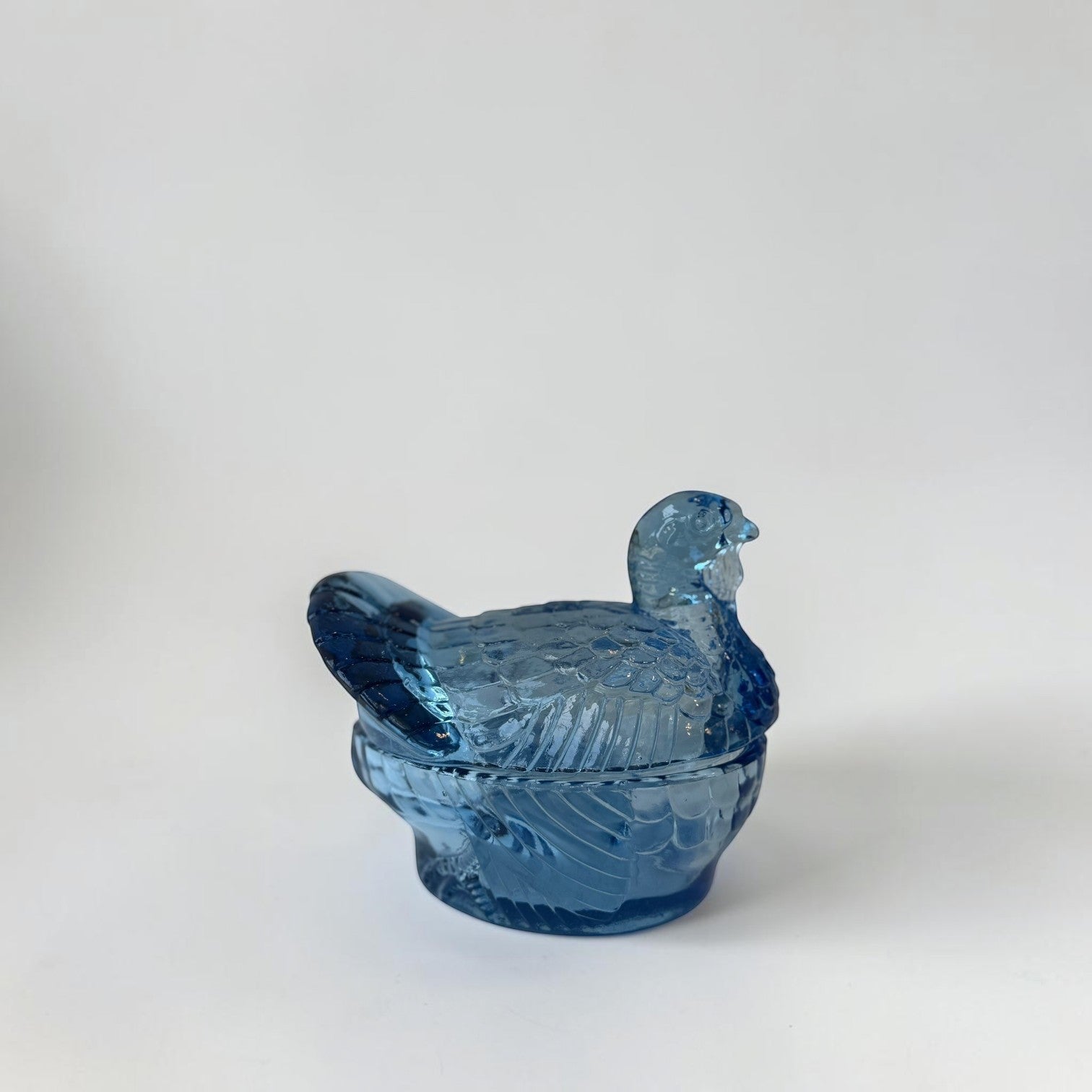 Her Good Eye blue glass bird trinket dish with intricate feather details and lidded compartment.