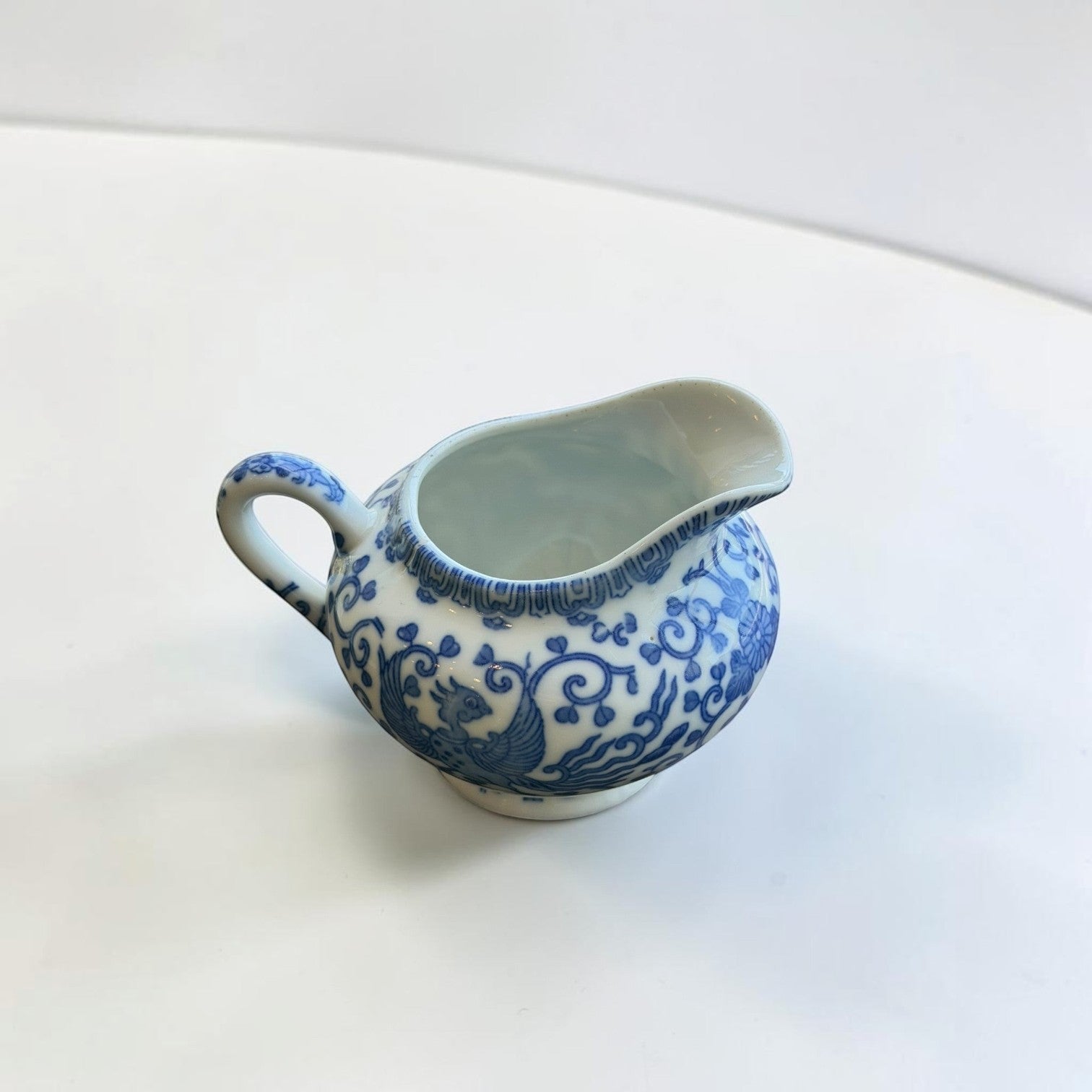 Her Good Eye blue and white porcelain creamer pitcher with floral and phoenix motifs in Chinoiserie style.