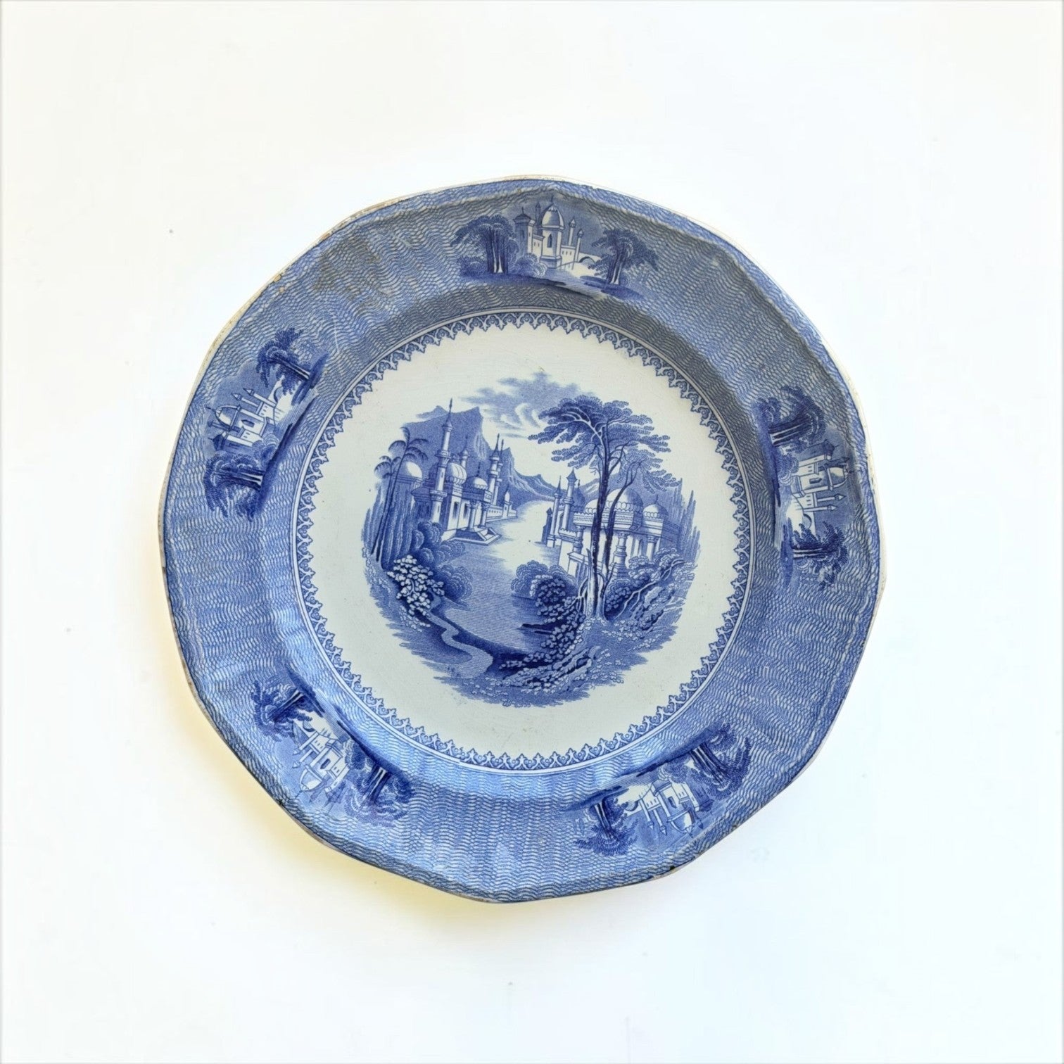 Her Good Eye vintage blue and white transferware dinner plate with a detailed pastoral riverside landscape scene.