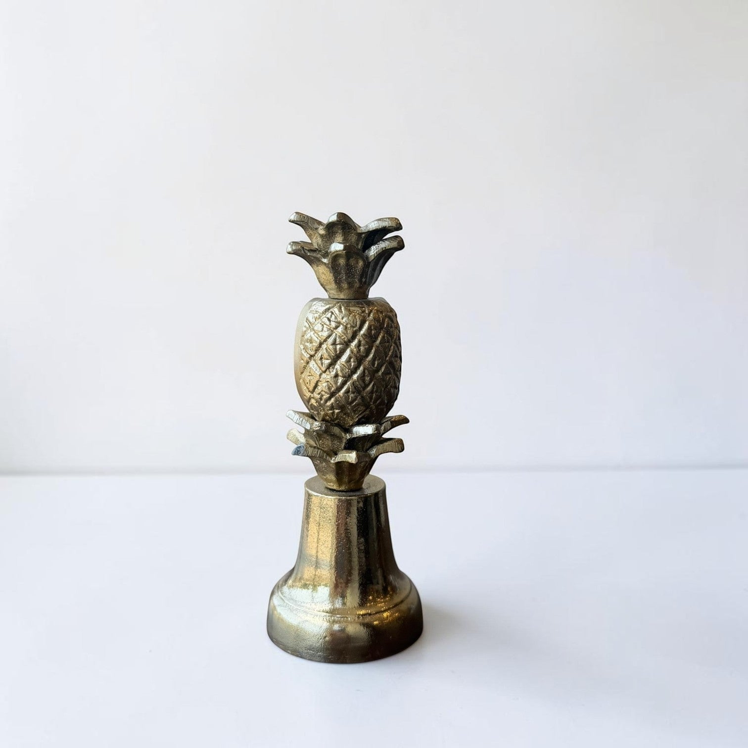 Her Good Eye brass pineapple decorative accent with textured body and flared base. Tropical home decor.