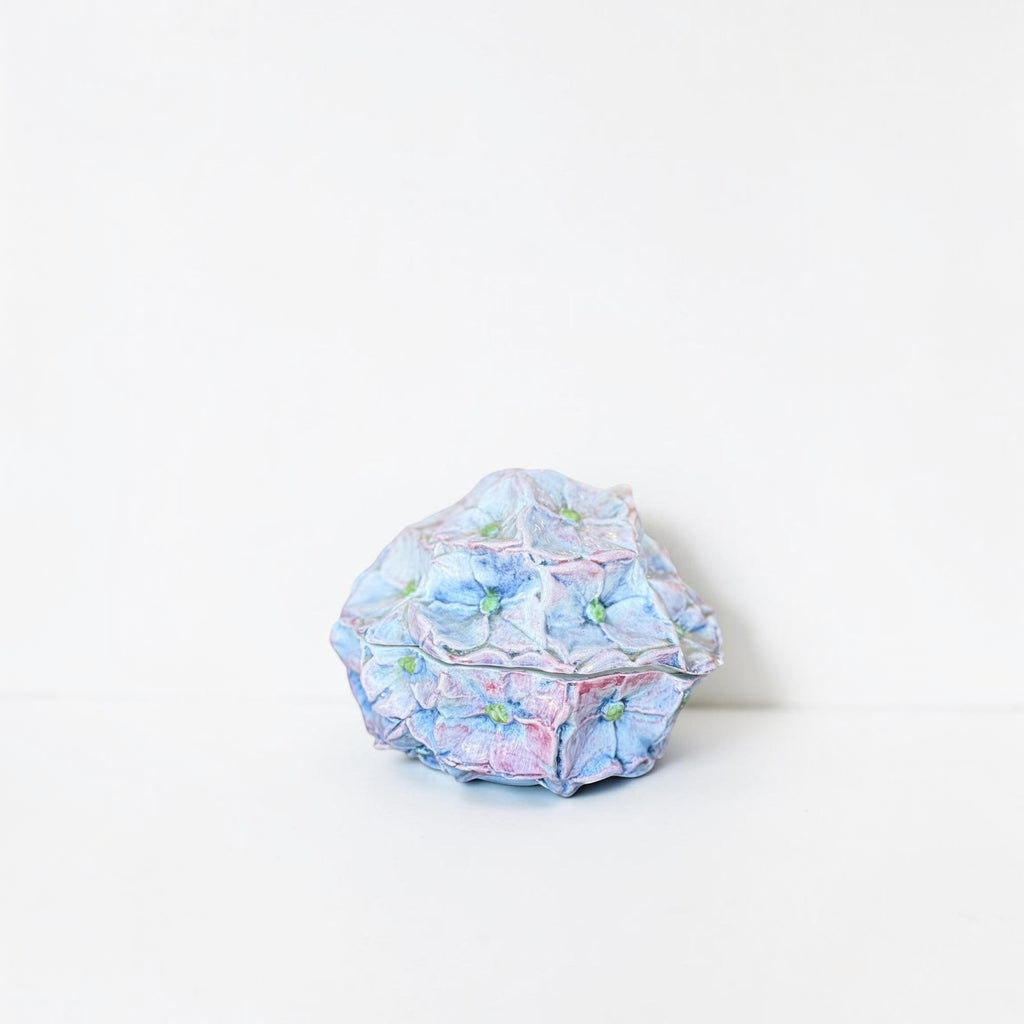 Her Good Eye handcrafted ceramic hydrangea trinket box in pastel blue and pink with intricate petal detailing.