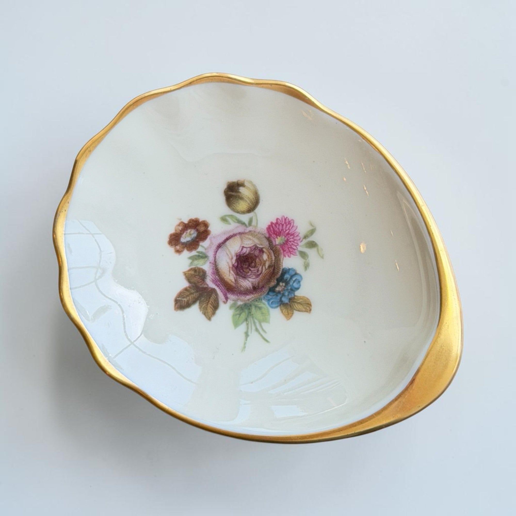Her Good Eye floral gilded porcelain trinket dish with scalloped gold rim and vintage floral bouquet painting.