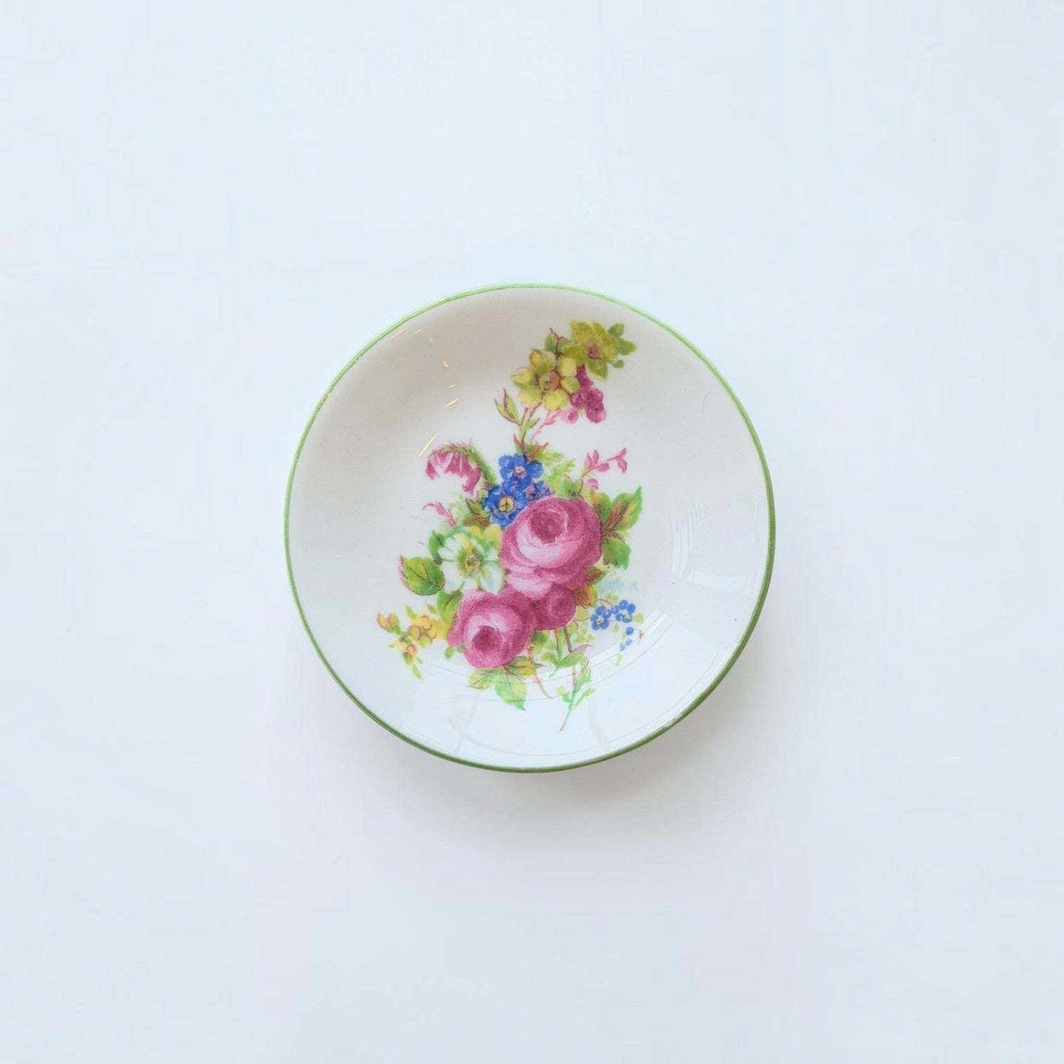 Her Good Eye vintage porcelain trinket dish with hand-painted pink and blue floral bouquet and green rim.
