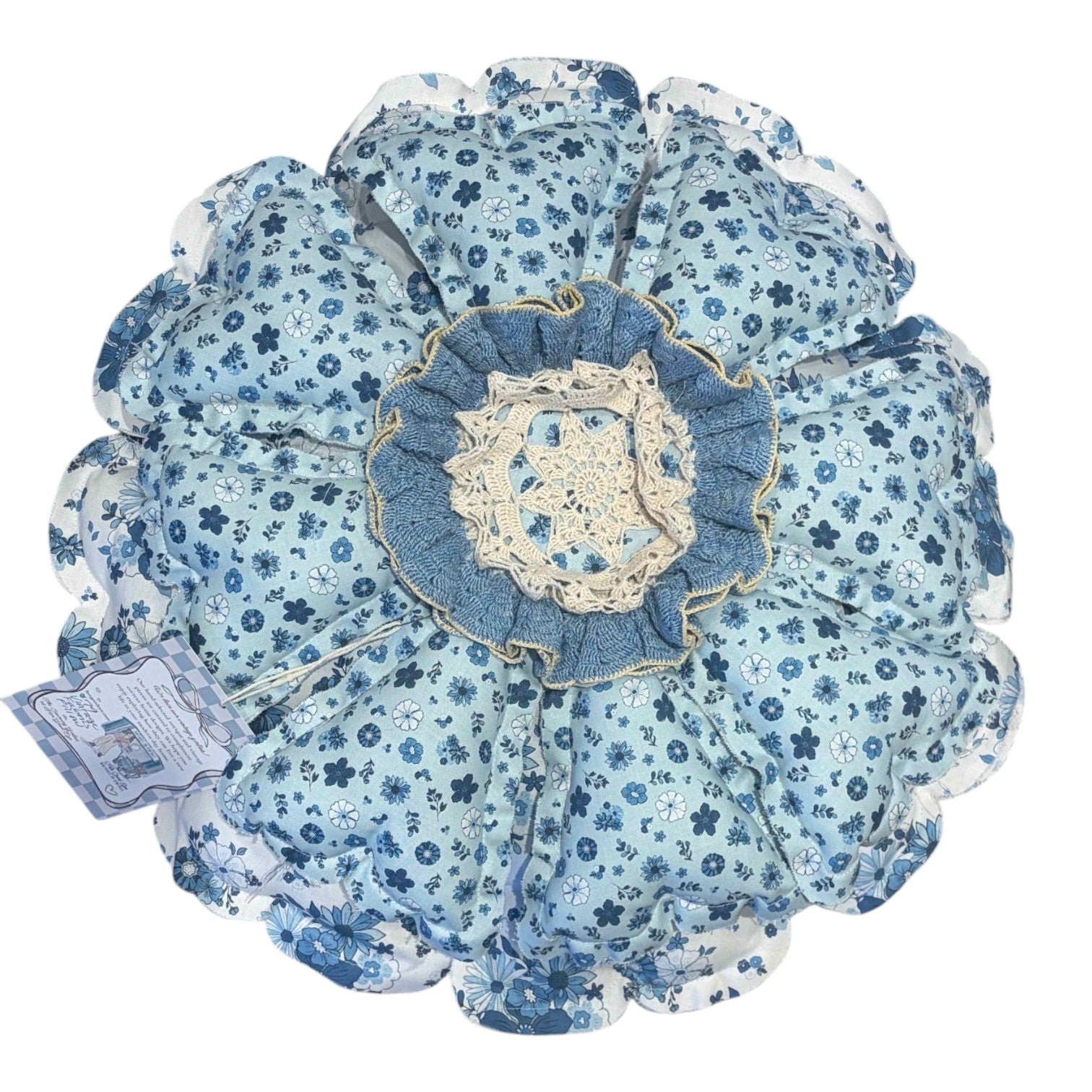 Her Good Eye blue and white floral fabric throw pillow with denim ruffle and crocheted lace center medallion.