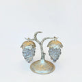 Her Good Eye vintage grape motif salt and pepper shakers with clear glass clusters on a silver-toned metal stand.