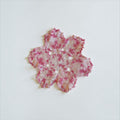 Her Good Eye handmade crochet doily in variegated pink and white yarn with an intricate floral openwork design.