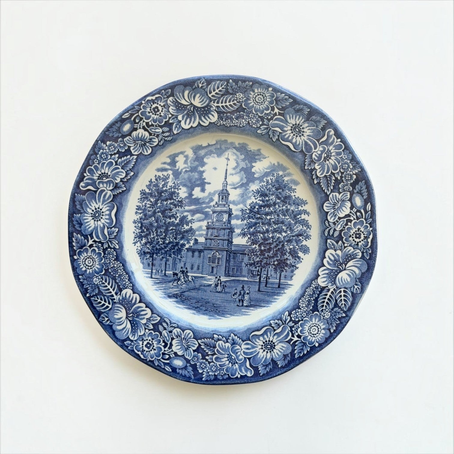 Her Good Eye blue and white ceramic plate featuring an Independence Hall historical scene with ornate floral border