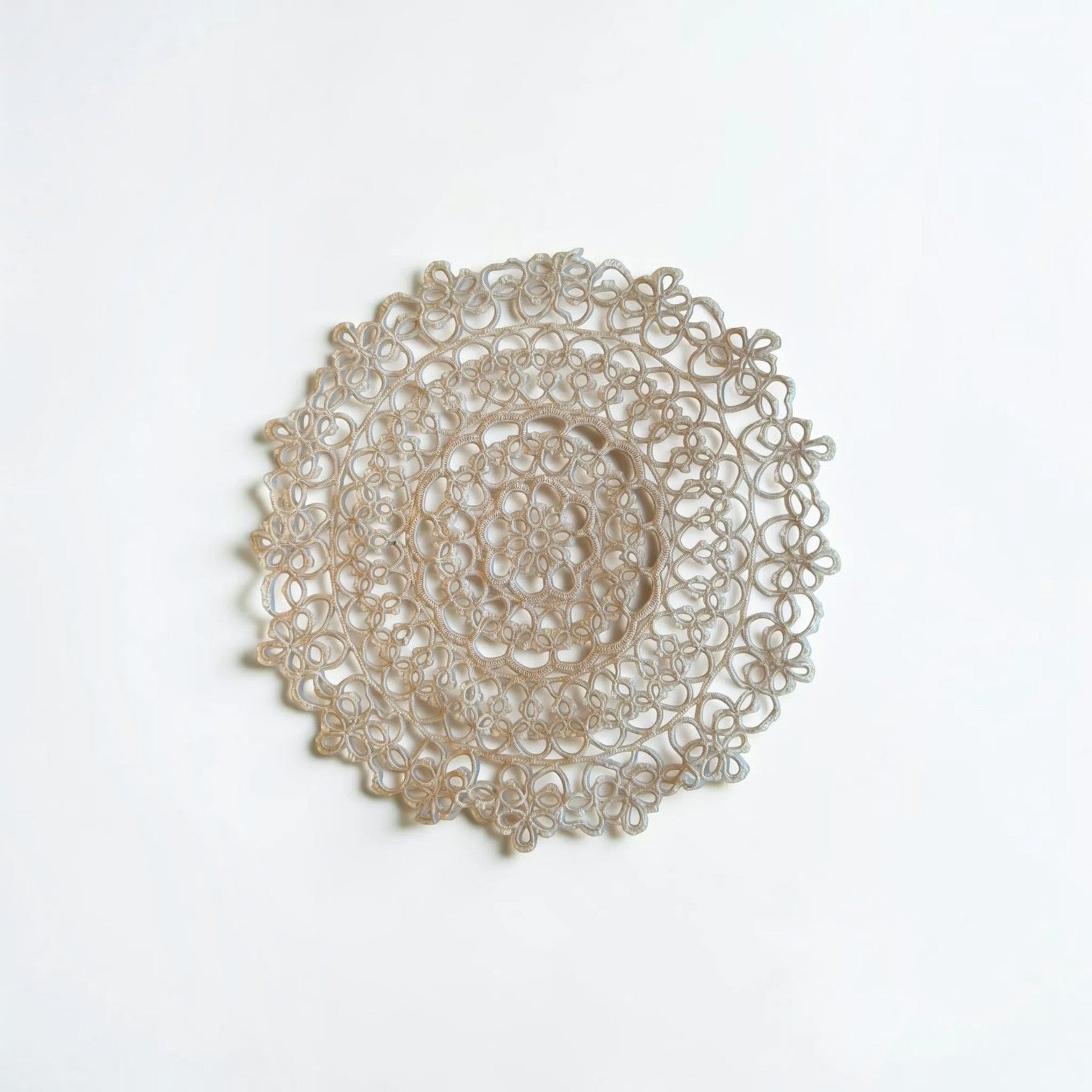 Her Good Eye handcrafted circular lace doily with intricate openwork patterns in a neutral beige tone.