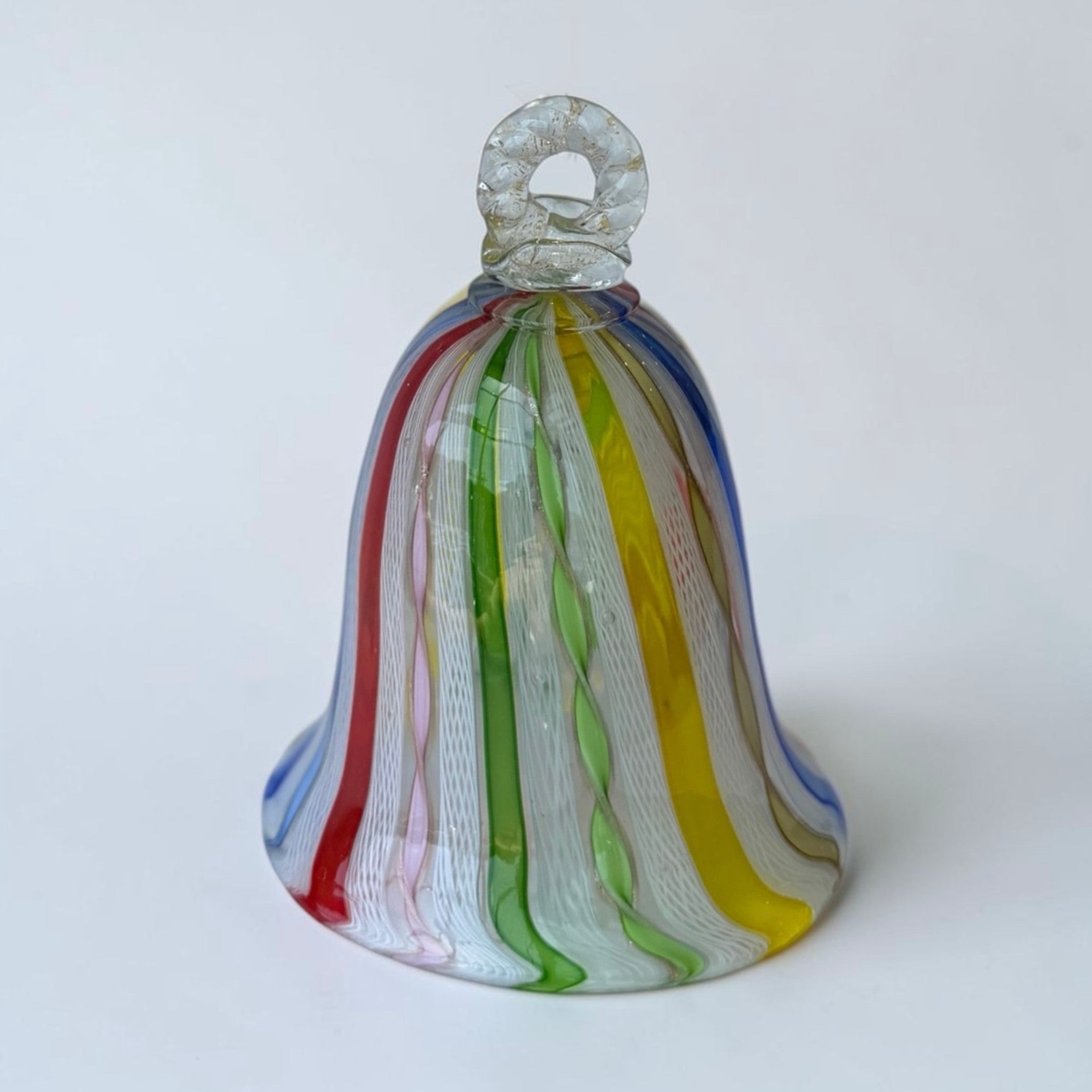 Her Good Eye hand-blown glass bell ornament with red, blue, green, yellow, and pink vertical stripes and white threads.