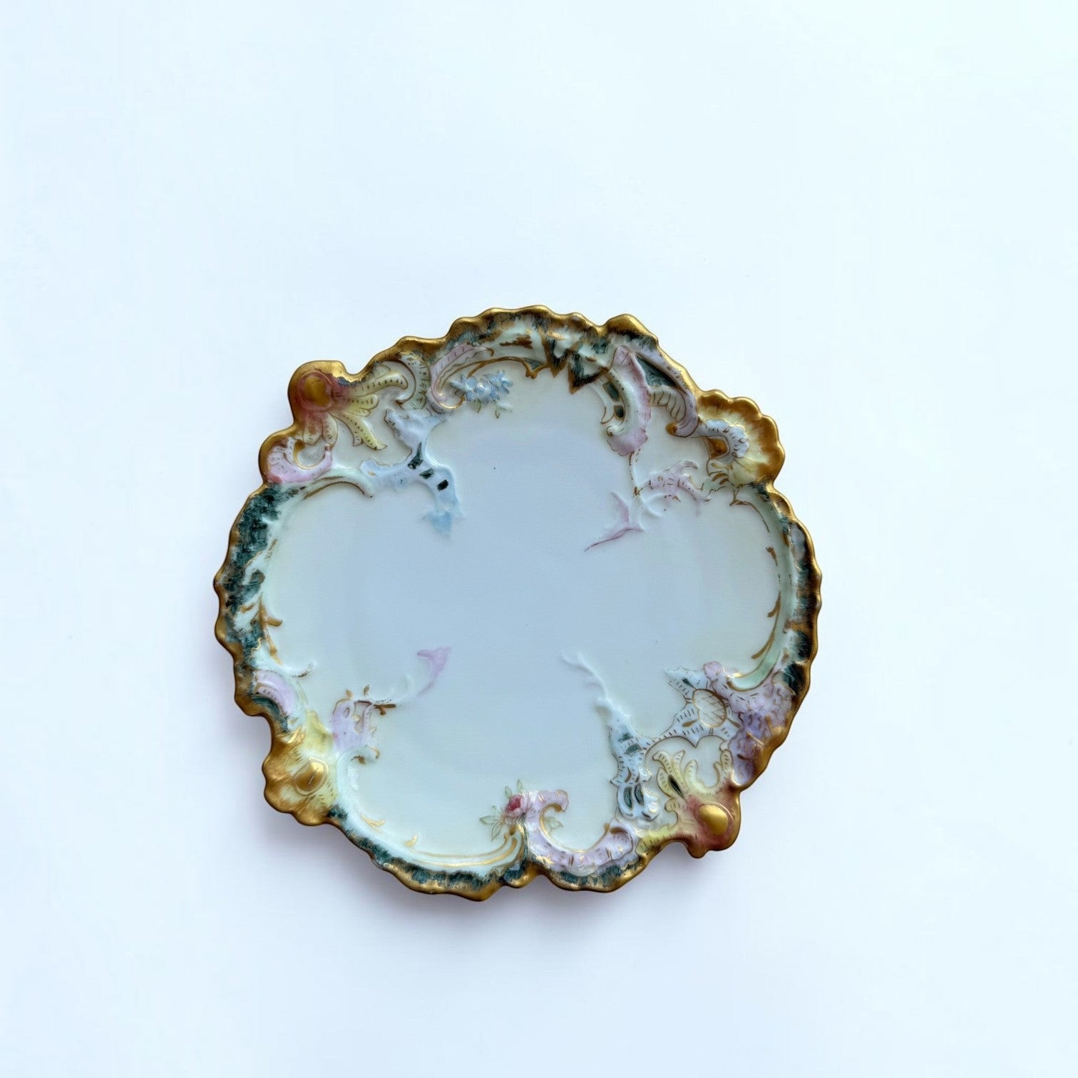 Her Good Eye ornate porcelain serving plate with scalloped edges, floral motifs, and gilded gold accents.