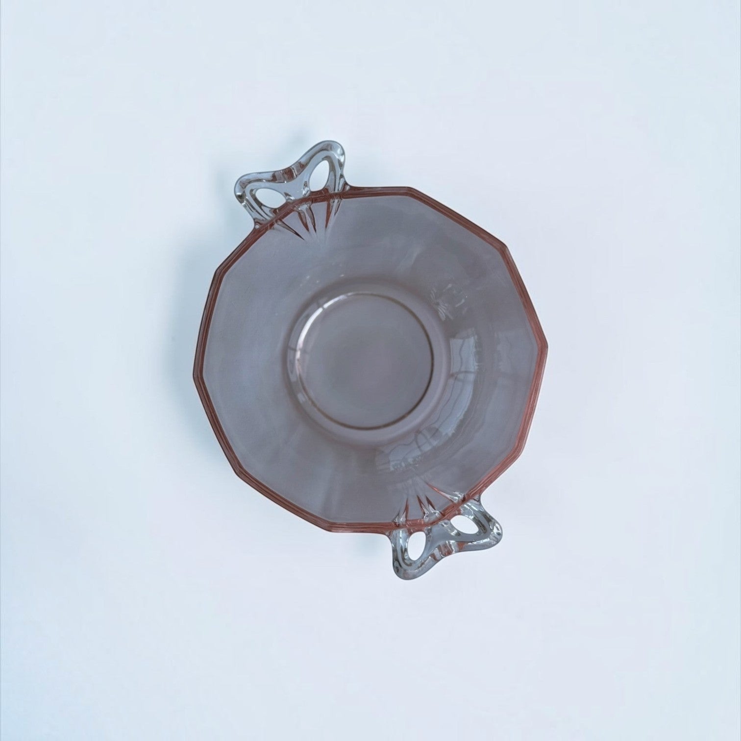 Her Good Eye vintage pink pressed glass serving bowl with an octagonal shape and two arched handles, top view.