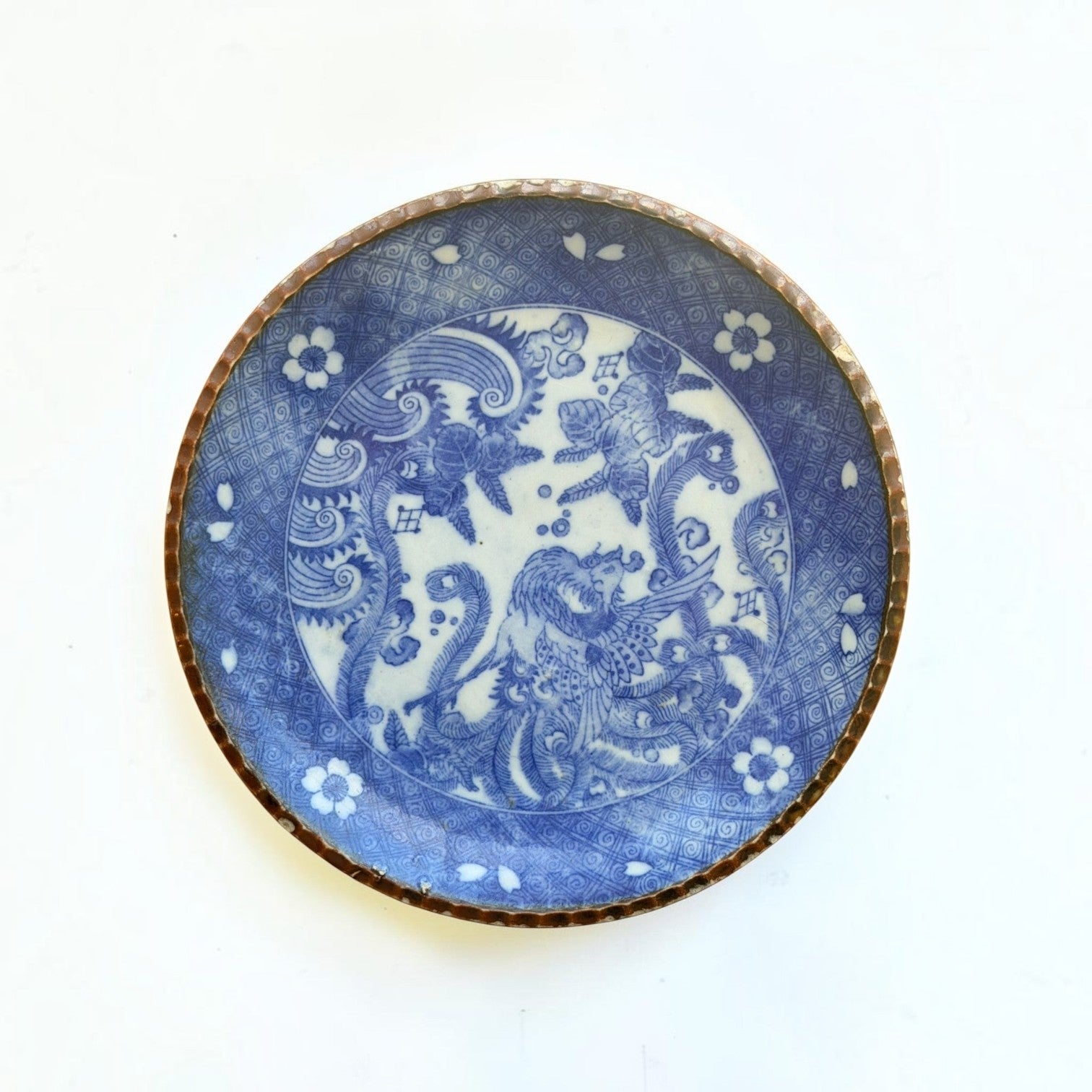 Her Good Eye vintage-inspired porcelain plate with cobalt blue phoenix and floral motifs and a textured metallic rim.