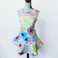 Her Good Eye handmade quilted patchwork apron featuring colorful hexagon fabric motifs in floral and gingham patterns.