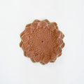 Her Good Eye handmade terracotta crochet table doily with a beige scalloped edge and intricate floral pattern.