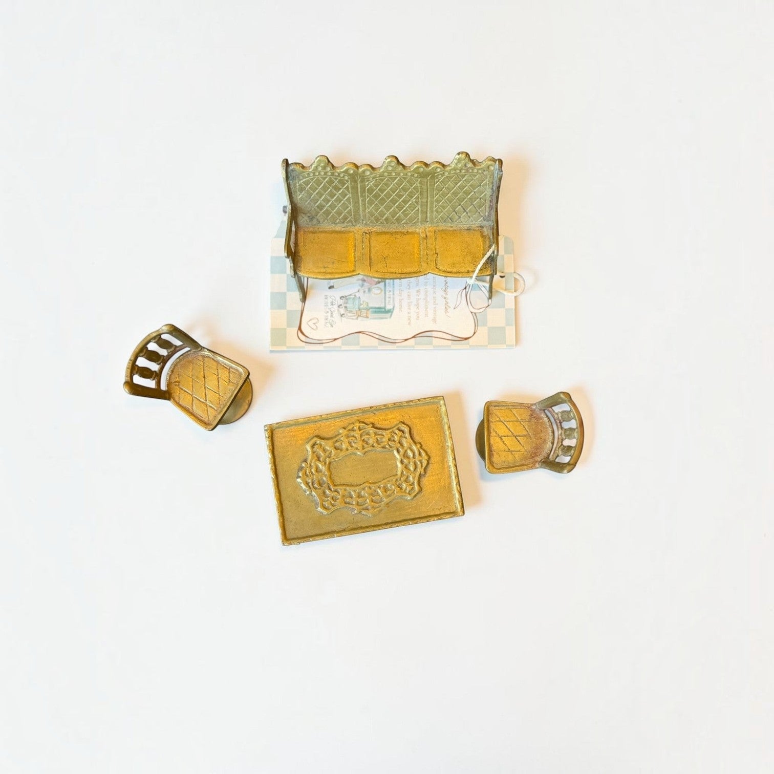Her Good Eye vintage brass dollhouse furniture set with a sofa, two armchairs, and an ornate rectangular coffee table.