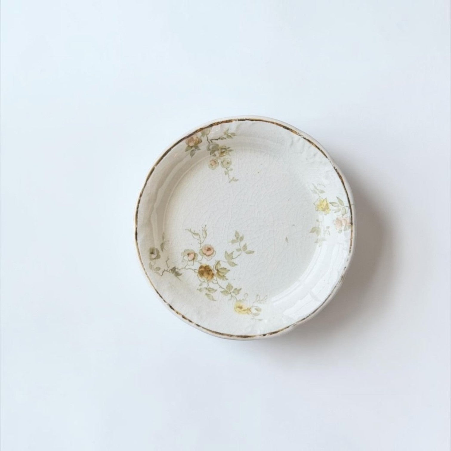 Her Good Eye vintage ceramic plate with yellow and sage floral pattern, crackle glaze, and gold-toned scalloped rim.