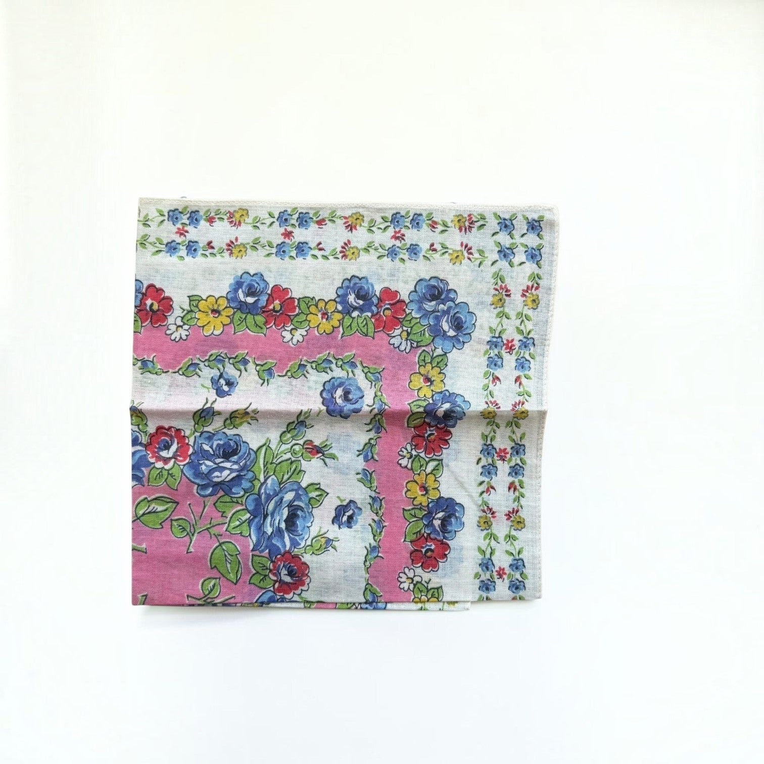 Her Good Eye vintage cotton handkerchief with blue roses, red and yellow flowers on a pink and white floral border.