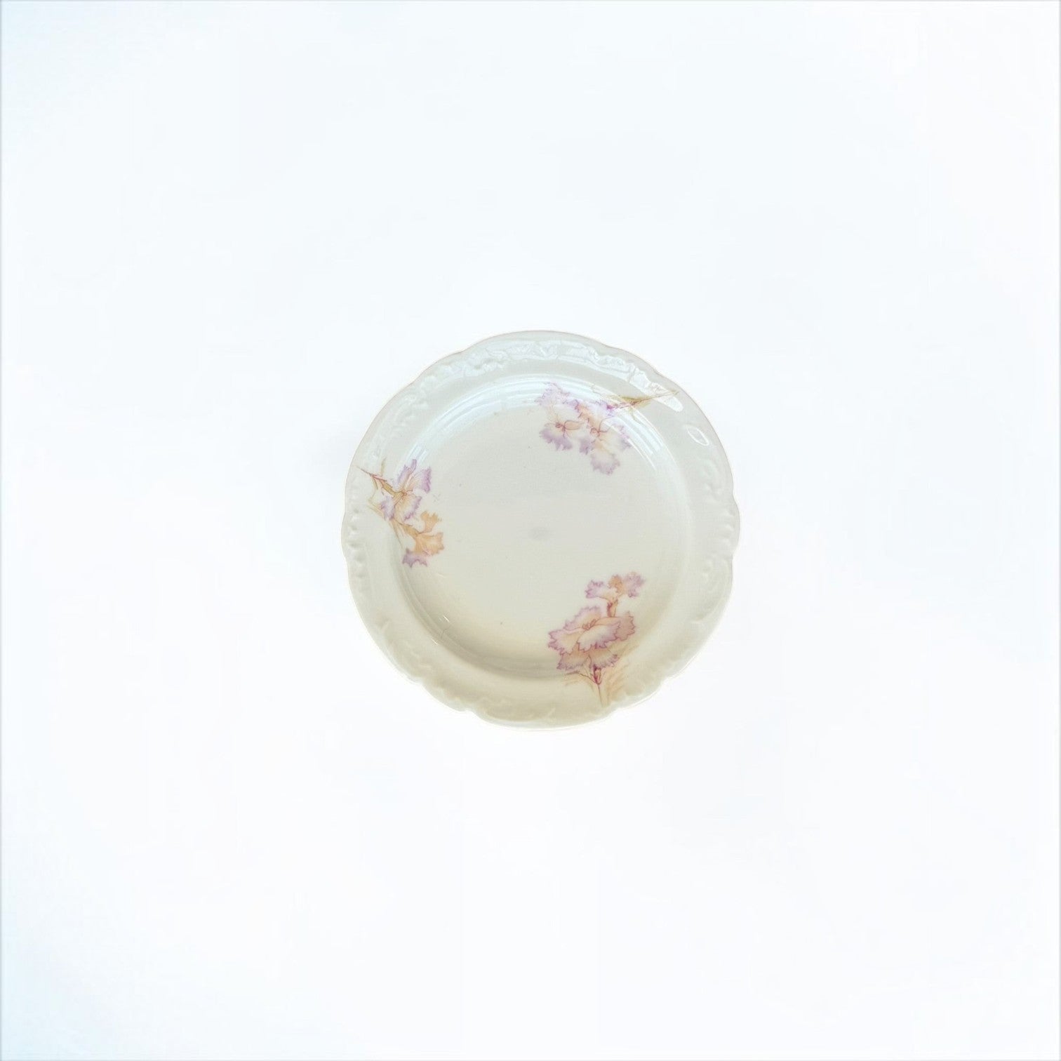 Her Good Eye vintage porcelain plate with scalloped edges and hand-painted lavender and peach floral motifs.