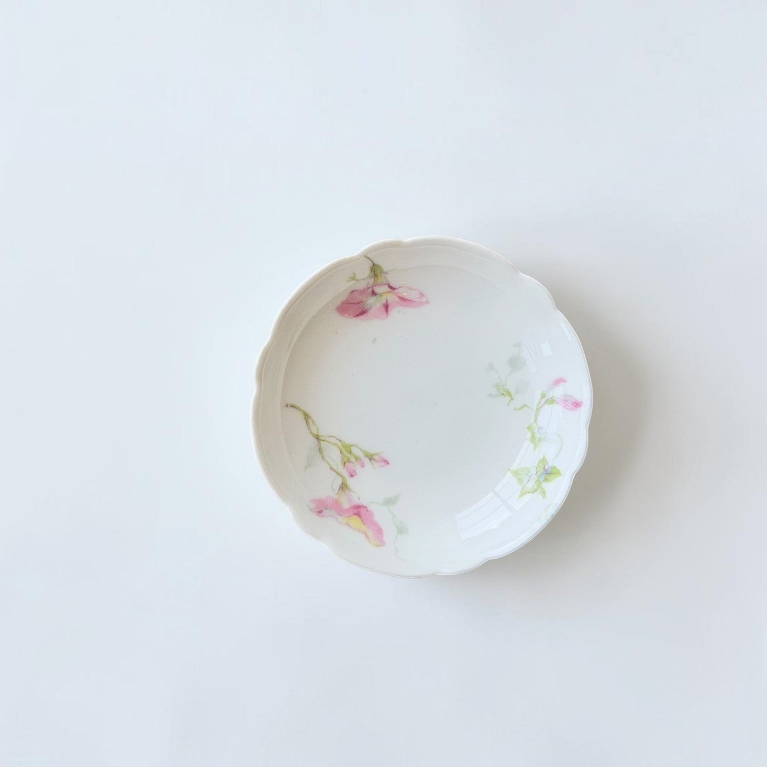 Her Good Eye vintage porcelain saucer with scalloped edges and delicate pink and sage green floral hand-painted motifs.